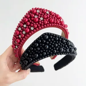 Primo piano di fasce per capelli retrò rosse e nere con lussuosi dettagli in perle e strass