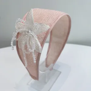Close-up of elegant pink wide headband with hand-beaded floral embellishment.