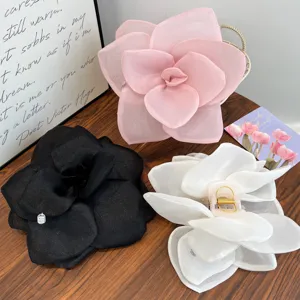 Detail view of oversized mesh rose flower hair clips in romantic pink, black, and white colors