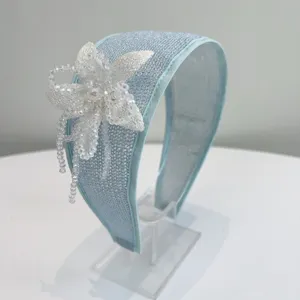 Detailed view of light blue wide headband with exquisite handmade beaded flower embellishment.
