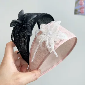 Detailed view of handmade beaded floral decorations on stylish black and pink wide headbands