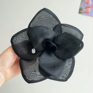Detailed view of a large black mesh fabric rose flower hair clip accessory