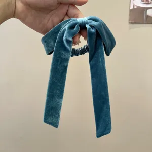Elegant teal velvet bow hair tie with long ribbons for graceful hairstyling