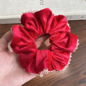 Makro-Detail von luxuriösem rotem Samt-Scrunchie mit Perlen