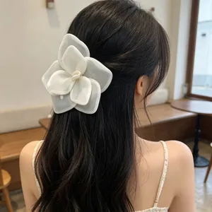 Oversized white mesh rose flower hair clip shown in a romantic half-up hairstyle