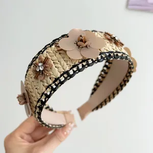 Λεπτομέρεια από πλεκτή στέκα raffia με λουλούδια από πούλιες και κρυστάλλινα στοιχεία