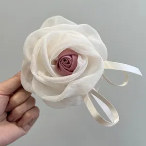 Primer plano de pinza para el pelo con rosa de malla y centro de satén rosa