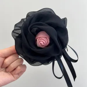 Vista detallada de la pinza para el pelo de rosa de malla negra con centro rosa