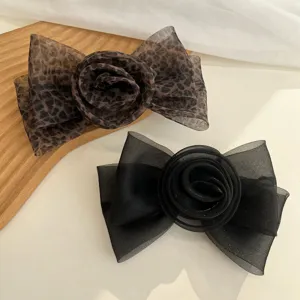 Détail macro de pinces à cheveux élégantes en maille rose avec léopard et nœuds