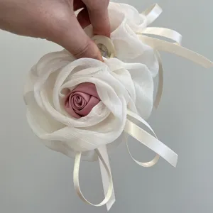 Vista detallada de una pinza para el pelo de malla con una elegante rosa de tela y cintas