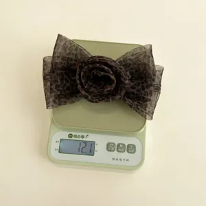 Mesure détaillée du poids de l'élégante pince à cheveux rose léopard en maille à 12,1 g
