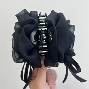 Primer plano de pinza para el pelo de rosa de gasa negra con lazo para mujer.