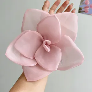 Detailed view of oversized romantic pink mesh rose flower hair clip with metal tag