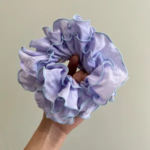 Primer plano de un coletero lavanda con diseño de volantes multicapa y bordes azules