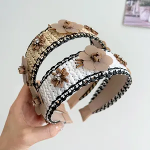 Κοντινό πλάνο από ψάθινες στέκες raffia με λουλούδια από πούλιες και στρας