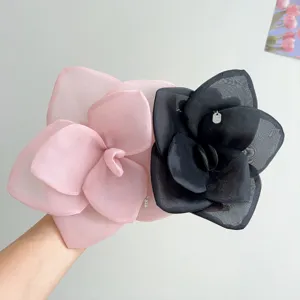Detailed view of oversized mesh rose flower hair accessories in romantic pink and black