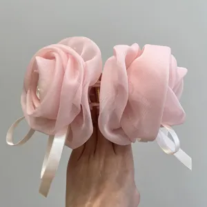 Vista detallada de una pinza para el pelo con forma de rosa rosa grande para el tamaño