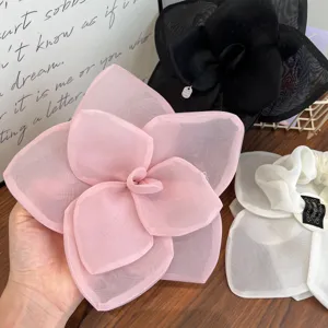 Detailed view of oversized organza rose flower hair clips and scrunchies in varied colors.