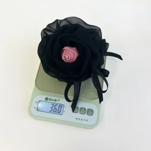 Vista detallada de una pinza para el pelo de rosa negra que pesa 36,0 g en una báscula