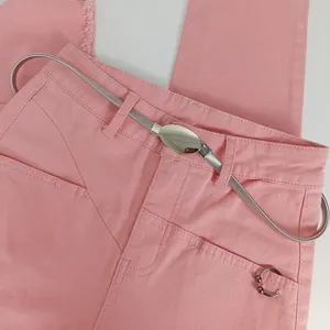 Pantalon en denim rose associé à une élégante ceinture en métal argenté pour femmes.