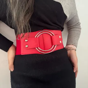 Women's wide red elastic waist belt with silver double ring buckle and metal rivets.