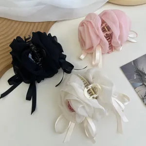 Detalle de pinzas para el pelo grandes y elegantes con rosa y lazo de gasa en tres colores.