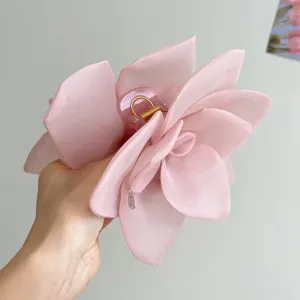 Detail shot of a large pink organza rose flower hair claw clip with multi-layer petals.