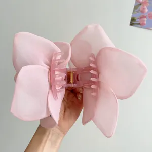 Detailed view of an oversized pink mesh rose flower hair claw clip for elegant women