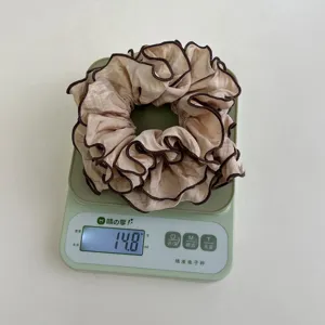 Detalle de un coletero plisado beige que muestra un peso de 14,8 g en una báscula