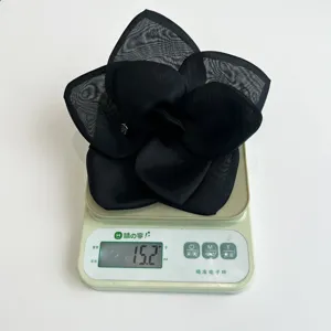 Black mesh rose hair clip weighing 15.2g on a digital scale