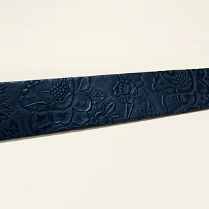 Ceinture en cuir noir gaufré avec motif floral détaillé pour un style élégant et moderne.