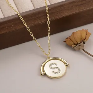 Vue détaillée d'un collier en or avec pendentif rotatif et lettre S en strass brillants
