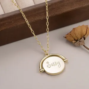 Zoom sur un collier avec pendentif rond rotatif doré gravé de l'inscription 'Sassy'.