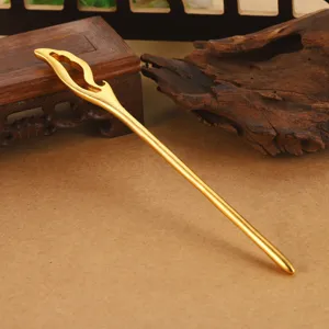 Detalle de una elegante horquilla dorada calada con nubes de estilo chino tradicional