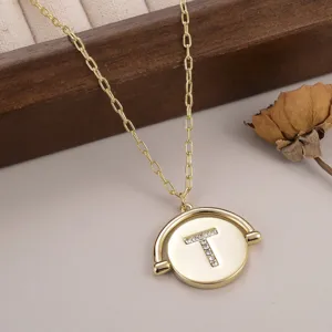 Vue détaillée du collier à pendentif rotatif doré avec lettre T en cristaux