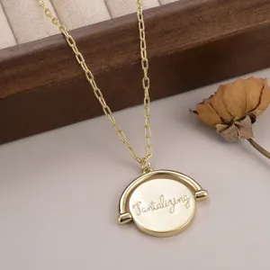 Vue détaillée du collier pendentif rond rotatif doré avec gravure Tantalizing