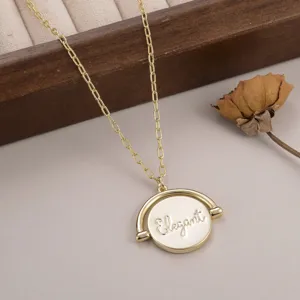 Vue détaillée du collier doré avec pendentif rond rotatif et gravure Elegant chic