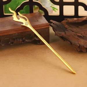 Close-up detail of golden flame-shaped hair stick with small green jade bead inlay for Hanfu