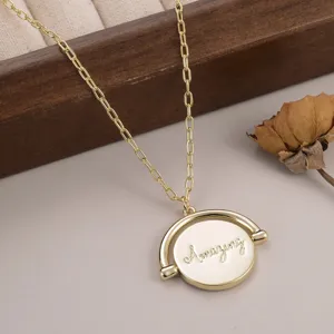 Gros plan d'un pendentif rotatif doré gravé du mot Amazing pour femme.