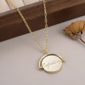 Vue rapprochée détaillée d'un collier à pendentif circulaire rotatif doré gravé