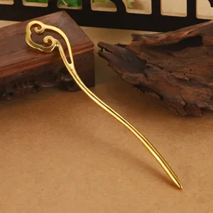 Primer plano de un palillo para el pelo dorado vintage con diseño de nube calada