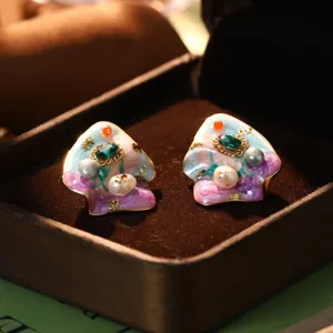 Detailed view of handmade enamel oil painting earrings with pearls and green stones