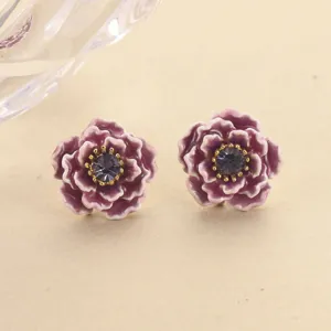 Detail view of elegant purple enamel flower stud earrings with center crystal.