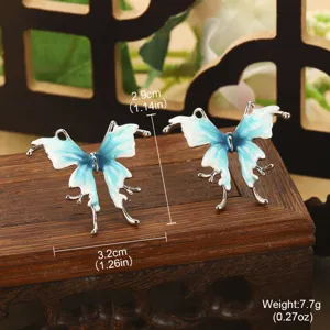 Détail montrant la taille et le poids des boucles d'oreilles papillon émaillées bleues