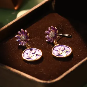 Close-up detail of vintage purple enamel flower drop earrings in a velvet jewelry box.
