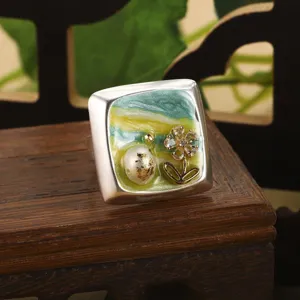 Gros plan détaillé d'une bague carrée en émail vintage avec perle et fleur en or