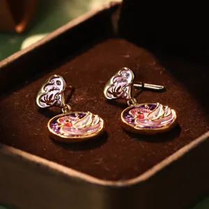 Macro view of exquisite enamel swan heart earrings displayed in a velvet jewelry box