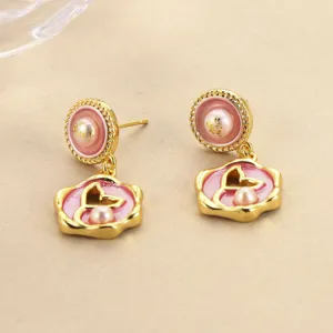 Detail shot of pink enamel flower earrings with elegant pearls and gold plating.