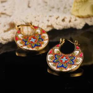 Detailed close-up of colorful enamel floral patterns on gold-toned hoop earrings