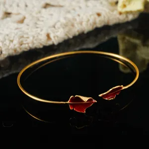 Detailed close-up showing the intricate texture of red enamel leaf on a gold bangle